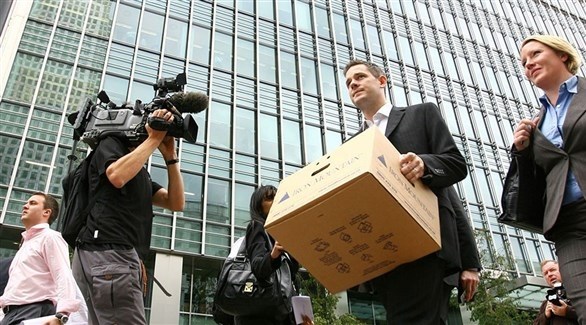 صحافيون يصورون موظفاً مسرحاً بعد انهيار ليمان براذرز في 2008 منطلق الأزمة المالية العالمية (أرشيف)