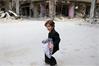 صبي سوري يحمل ملابس جديدة احتفالاً بعيد الفطر في ريف دمشق