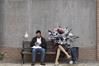 رجل يجلس بجانب منحوتة للفنان البريطاني بانكسي 