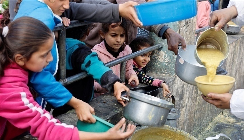 أطفال من غزة يتسابقون على ملء آنيتهم بطعام يسد جوعهم (وكالات)