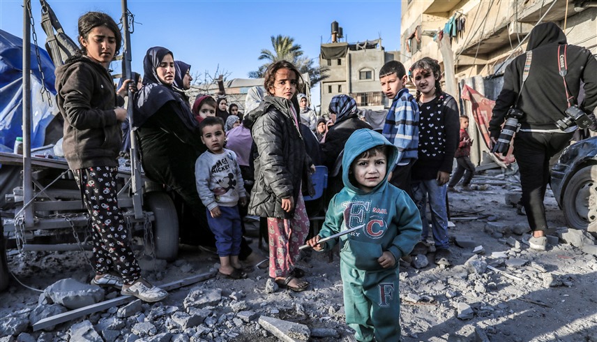 أطفال من غزة يقفون على أنقاض المنازل المدمّرة (أ ف ب) 
