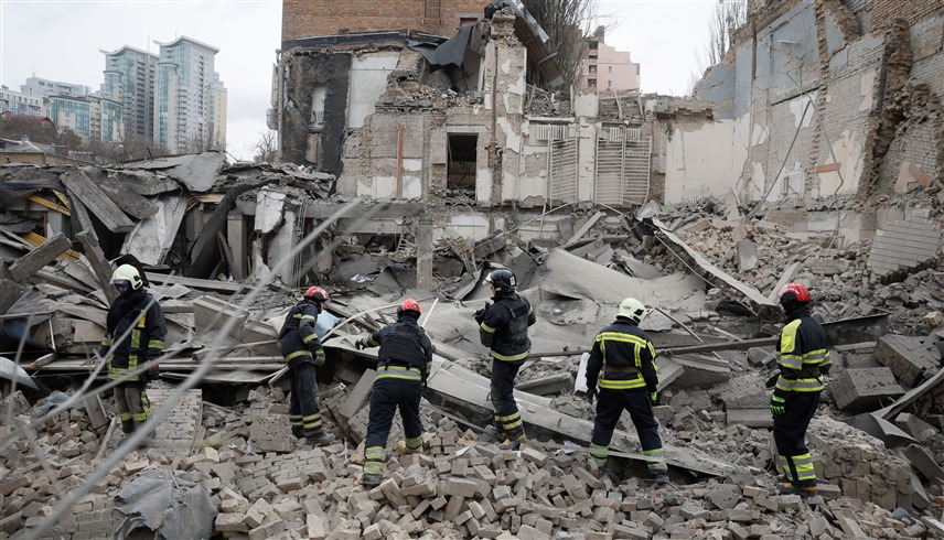 عمال إنقاذ فوق أنقاض مبنى دمر في قصف روسي لكييف (وكالات)