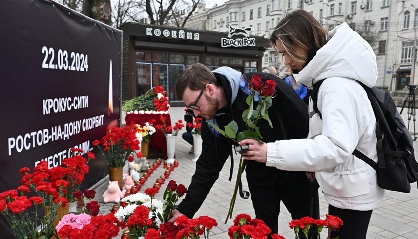 روسيان يضعان وروداً تكريما لضحايا الهجوم في موسكو (أرشيف)