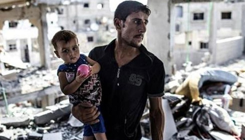 فلسطيني يحمل ابنته وسط الأنقاض في غزة (أرشيف)