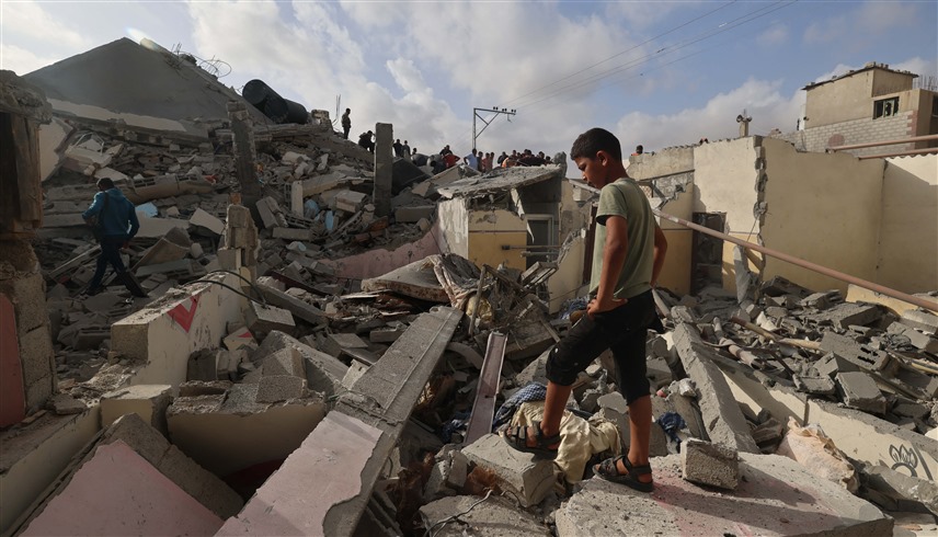 فتى فلسطيني يقف عند ركام منزل مدمر في رفح