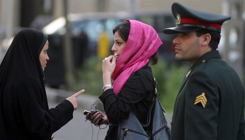 سيدة من شرطة الأخلاق تحذر امرأة إيرانية (رويتر)
