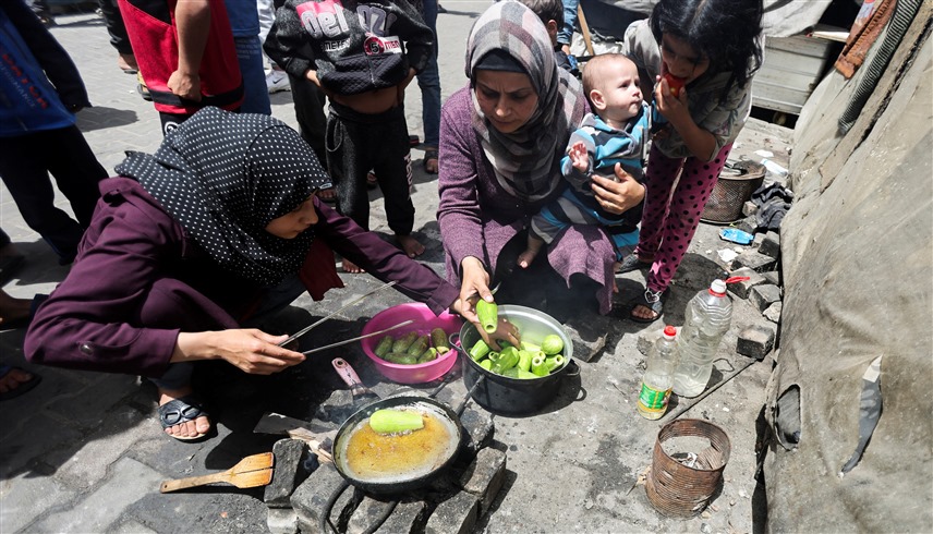 سيدات يصنعن الطعام في مركز إيواء بغزة (رويترز)