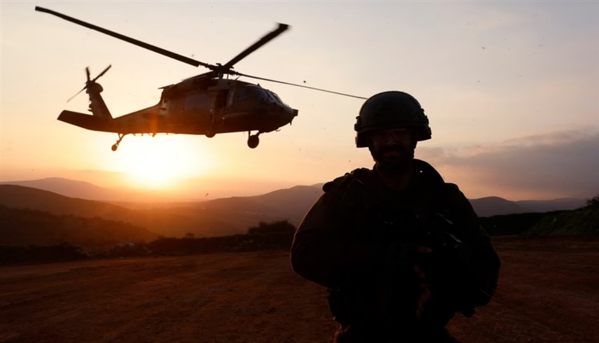 جندي إسرائيلي يراقب هليكوبتر عسكرية