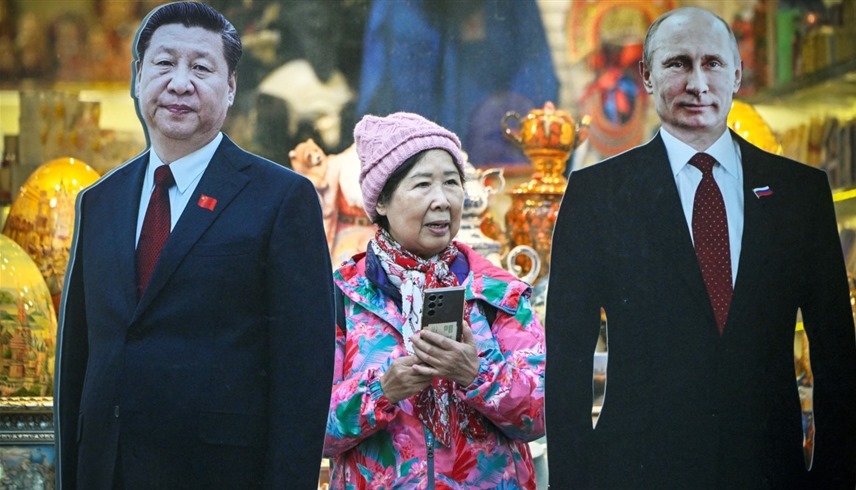 سائحة صينية بين مجسمين لبوتين وشي جين بينغ في موسكو (أرشيف)