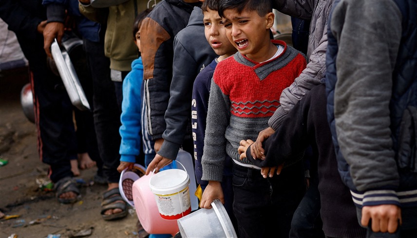 أطفال في غزة يحاولون الحصول على طعام خيري (رويترز)