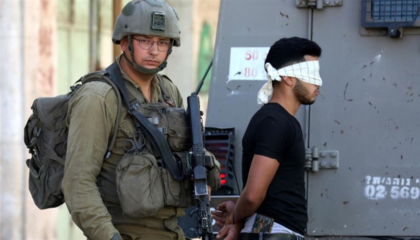 جندي إسرائيلي يعتقل فلسطينياً في الضفة الغربية (أرشيف)