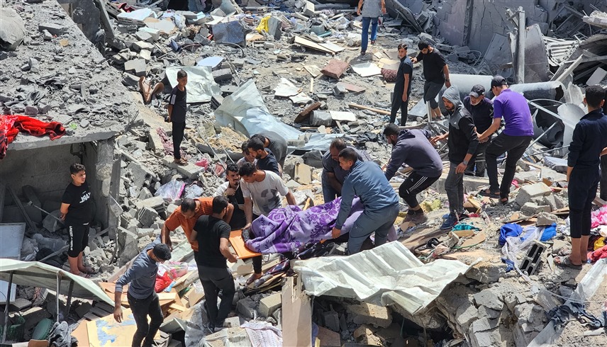 شبان ينتشلون جثامين ضحايا قتلوا في قصف إسرائيلي على غزة (رويترز)