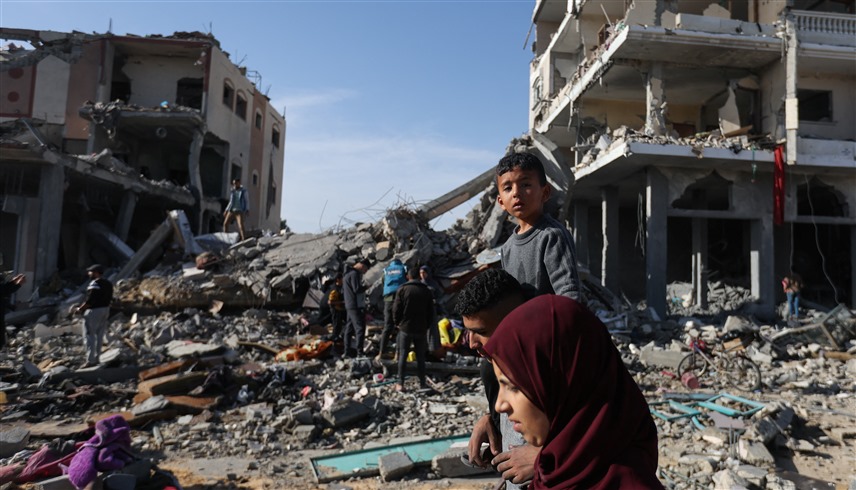 فلسطينيون في مواقع دمرها القصف في غزة (رويترز)