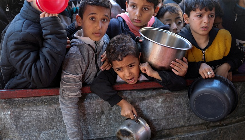 أطفال في غزة ينتظرون للحصول على طعام من مطبخ خيري (رويترز)