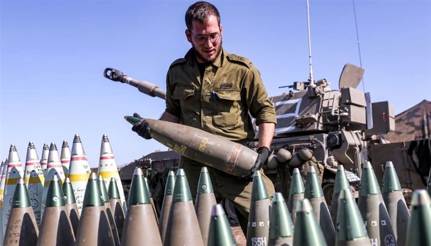 جندي إسرائيل يحمل قذيفة مدفعية قرب حدود غزة (أرشيف)