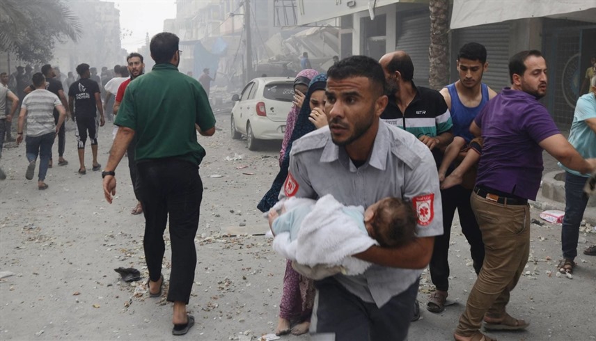 مسعف فلسطيني يحمل طفلة أصيبت في قصف إسرائيلي لغزة (رويترز)