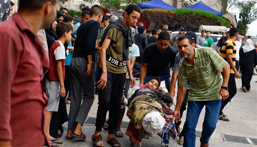 نقل طفل مصاب لأحد المستشفيات في غزة (رويترز)