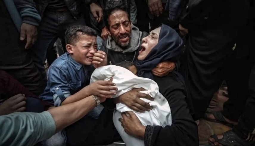 فلسطينية تحتضن طفلها بعد مقتله في قطاع غزة (أرشيف)