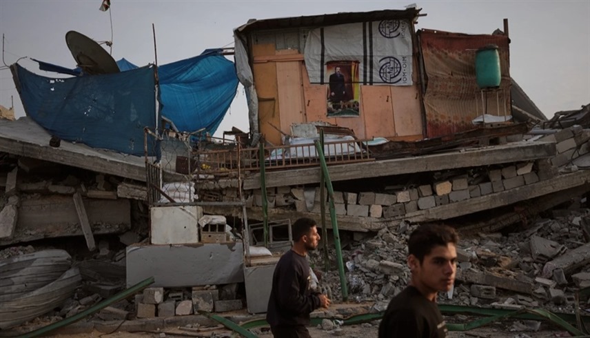 فلسطينيان وسط أكوام الأنقاض في قطاع غزة (أ ب)