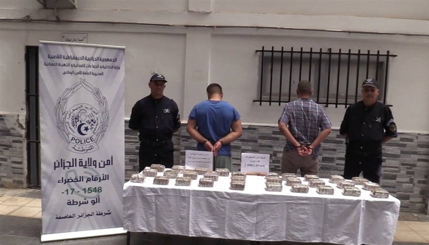 صورة عرضها التلفزيون الجزائري لبعض أعضاء العصابة مع جانب من المخدرات المحجوزة (إكس)