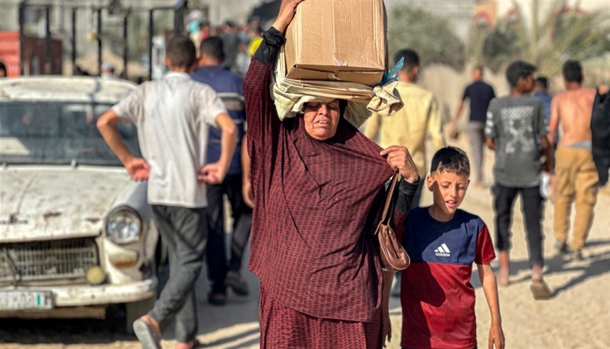فلسطينية تحمل مساعدات في غزة (أ ف ب)