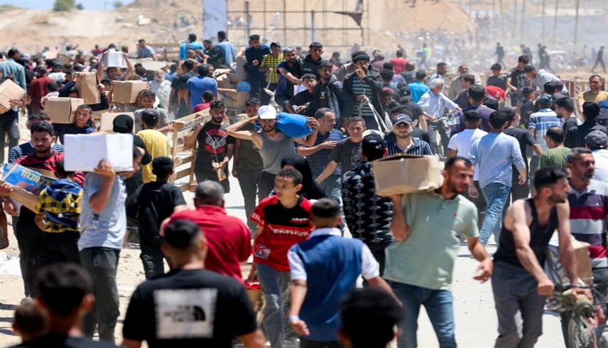 فلسطينيون يحملون مساعدات من مؤسسة غزة الإنسانية (أرشيف)