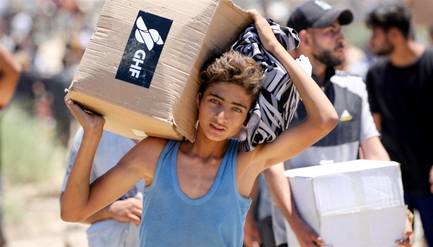  فلسطيني يحمل مساعدات من مؤسسة غزة الإنسانية (أ ف ب)