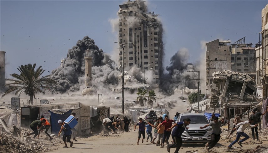 فلسطينيون في غزة يهربون بعد تدمير برج سكني في المدينة (أرشيف)