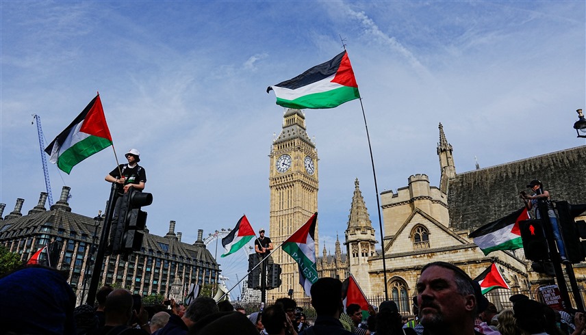 أعلام فلسطينية في لندن خلال مسيرة تطالب بإنهاء حرب غزة (رويترز)