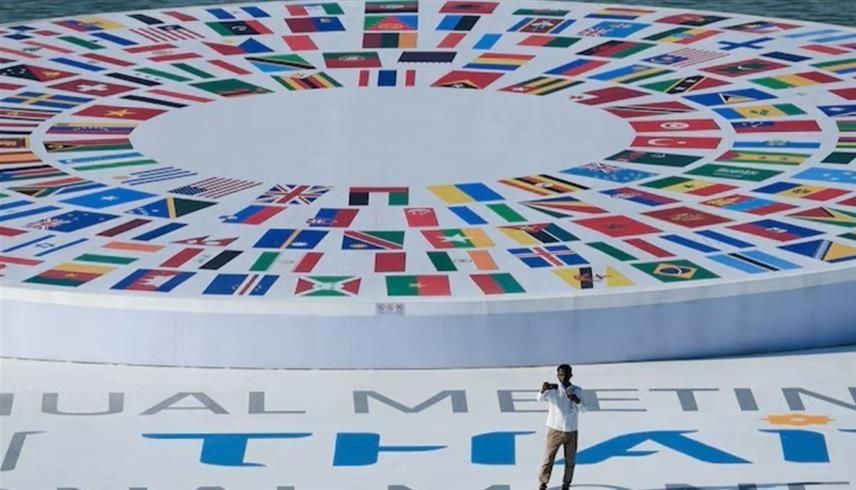 شخص يحمل هاتفاً بالقرب من مقر الاجتماعات السنوية لصندوق النقد الدولي والبنك الدولي لعام 2026 (رويترز)