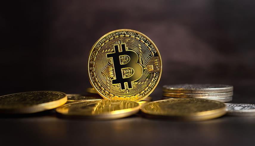قطعة معدنية تحمل شعار بيتكوين (رويترز)