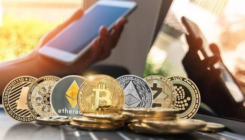 قطع معدنية تحمل شعارات للعملات المشفرة (رويترز)