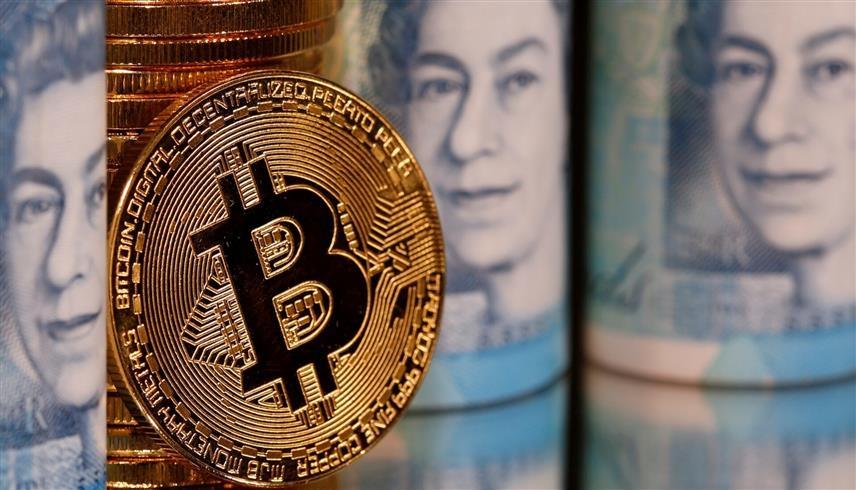 قطعة معدنية تحمل شعار بتكوين (رويترز)