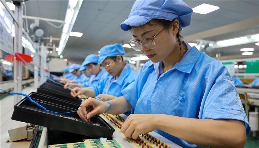 عمال يجمعون شرائح إلكترونية في الصين (أ ف ب)