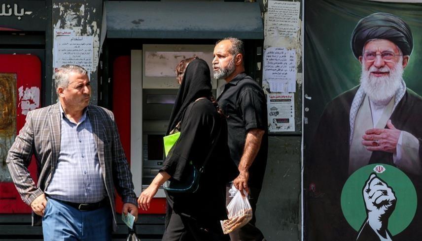 مارة أمام بنك في طهران (أ ف ب)