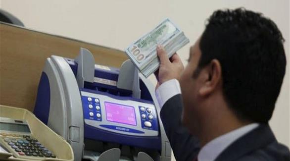 صراف مصري يعد أوراقاً من فئة 100  دولار (أرشيف)