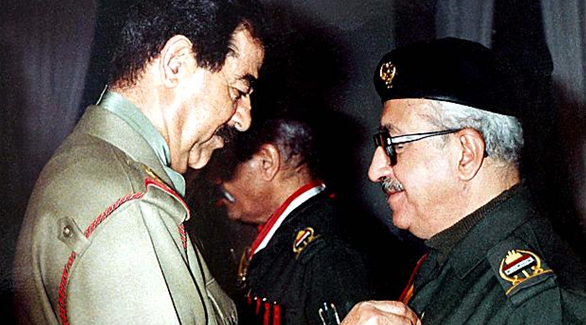 الرئيس العراقي الراحل صدام حسين يقلد وزير خارجيته آنذاك طارق عزيز وساماً(أرشيف)
