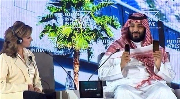 ولي العهد السعودي الأمير محمد بن سلمان يرفع هاتفين للدلالة على الفارق بين الماضي والمستقبل.(أرشيف)