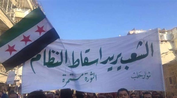 متظاهرون سوريون يحملون لافتة كتب فيها :الشعب يريج إسقاط النظام.(أرشيف)