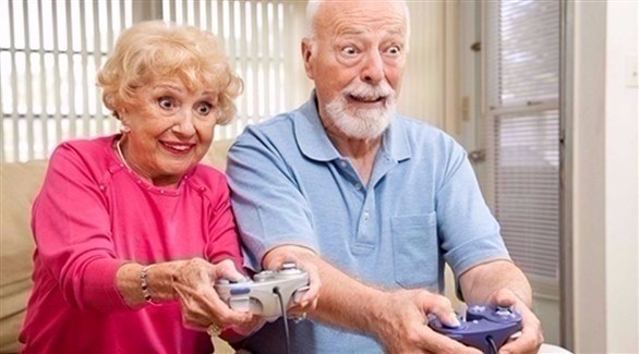 مُسنة ومسن يلعبان لعبة كمبيوتر (أرشيف)
