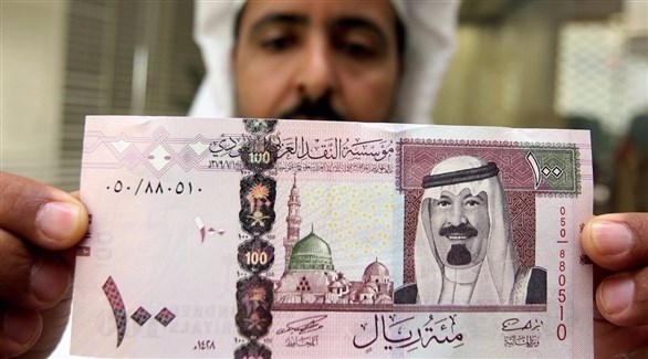 شخص يحمل عملة نقدية سعودية (أرشيف / غيتي)