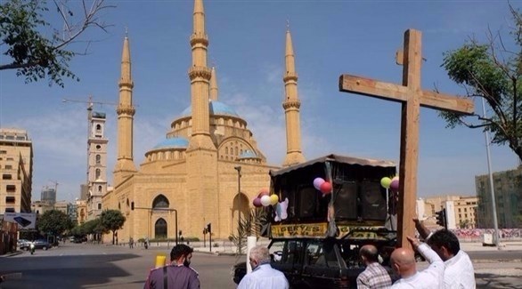 شبان يحملون صليباً خشبياً أمام مسجد محمد الأمين وسط بيروت. (أرشيف)
