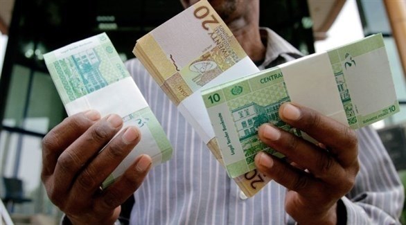 سوداني يعرض أوراقاً نقدية من فئة 10 و 20 جنيهاً (أرشيف)