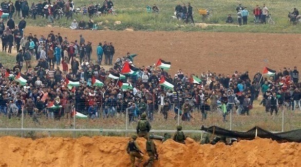 متظاهرون فلسطينيون في مواجهة جنود إسرئيل على السياج الأمني في غزة (أرشيف)