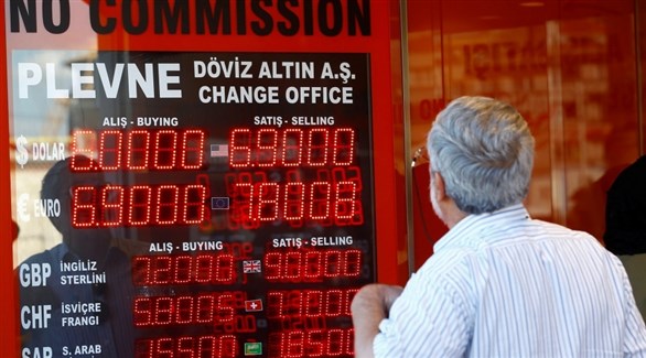 تركي يتابع تراجع الليرة أمام الدولار على شاشة إلكترونية أمام محل صرافة في اسطنبول (أرشيف)