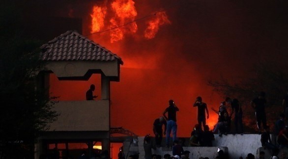 عراقيون أمام مبنىً حكومي يحترق في احتجاجات البصرة الأخيرة (أرشيف)