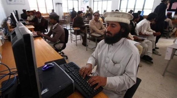 رجال داخل أحد المجمعات يستخدمون الكومبيوتر (أرشيف)