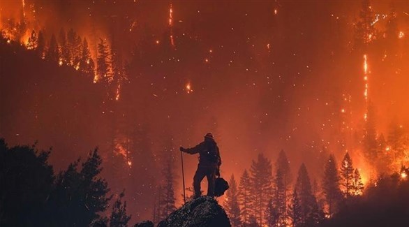 رجل اطفاء يقف أمام لهب النيران في كاليفورنيا 