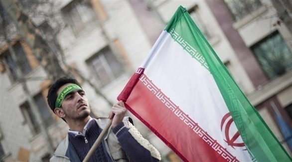 مجند من الباسيج يحمل العلم الإيراني.(أرشيف)