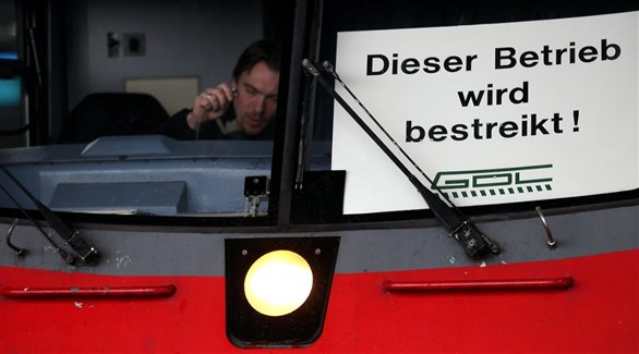 سائق قطار ألماني وإلى جانبه لوحة عليها إشعار بالإضراب عن العمل (أرشيف)